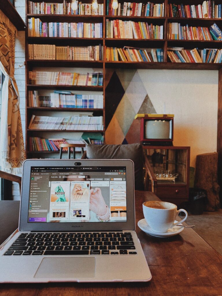 open laptop in front of a bookshelf with different types of print materials and an analogue tv system
