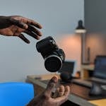 the hands of a black man lurch to catch his falling camera