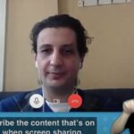 Person speaking on a video call with an ASL interpreter in the bottom corner of the screen