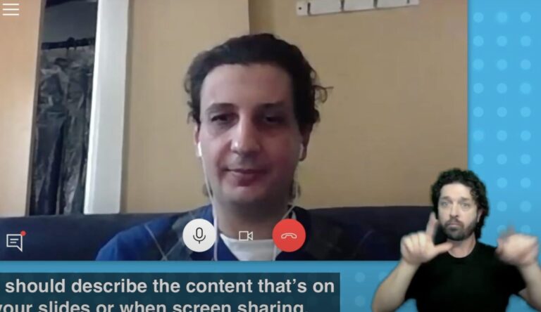 Person speaking on a video call with an ASL interpreter in the bottom corner of the screen