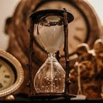 sepia photo of different kinds of clocks and hourglasses