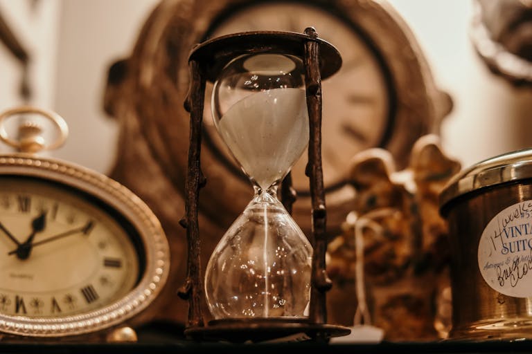sepia photo of different kinds of clocks and hourglasses